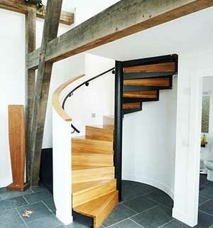 oak spiral stair leadnign to a mezzanine level. White walls and tiled floor