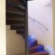 spiral stair with walnut steps and a curved wall with handrail mounted