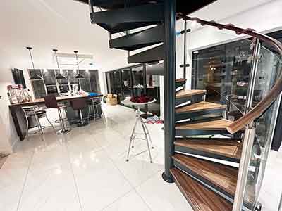 curved spiral stair with dark wood steps and curved glass