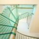 view looking up at a glass step on a spiral staircase in a house