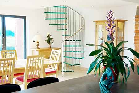 kitchen diner with table and chairs with a glass spiral staircase