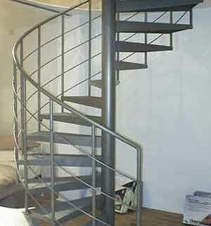 light grey steel spiral staircase in front of a wall
