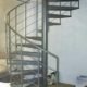light grey steel spiral staircase in front of a wall