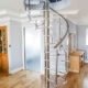 A living space with a timber floor and an acrylci spiral stair