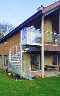 external spiral stair leading to a walkway of a house
