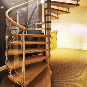 modern spiral with oak steps and glass balustrade with black wall behind