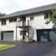 external front shot of a house with white render and tarmac drive and sky above