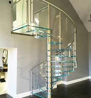 living room with glass spiral stair and grey wall behind