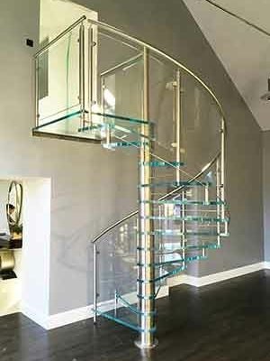 living room with glass spiral stair and grey wall behind