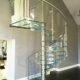 living room with glass spiral stair and grey wall behind