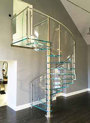 living room with glass spiral stair and grey wall behind