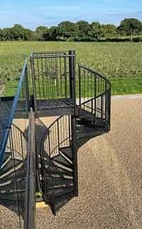 outside shot showing sky, a vineyard and a black spiral in foreground