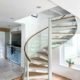steel, wood and glass spiral stair in a house, kitch seen behind
