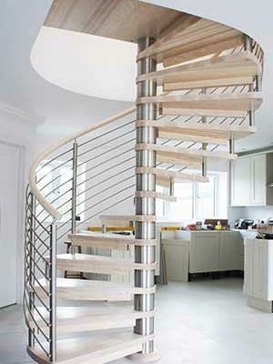 spiral stair in light wood with kitchen on show behind and a window