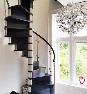 tight black wooden spiral stair with large window
