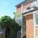 oputdoor shot of rear of house of brick with spiral stair