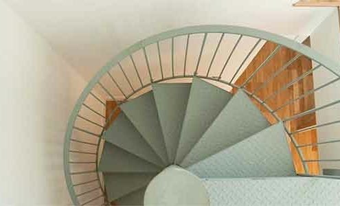 view from above of a light green spiral staircase