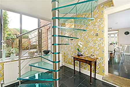 side view of a hallway with a large window to rear with glass a spiral staircase