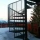 the alps in the background and a black spiral stair in the foreground