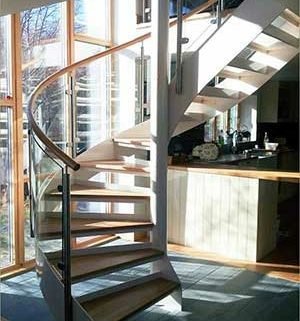 white and wood spiral stair in a house with large window
