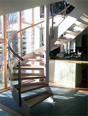 white and wood spiral stair in a house with large window