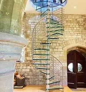 tall glass spiral staircase in a church conversion