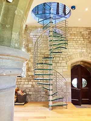 tall glass spiral staircase in a church conversion