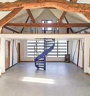 blue steel spiral in a rustic barn conversion - timber beams
