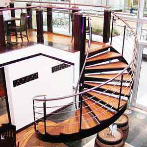 restaurant setting with spiral stair rising to mezzanine level