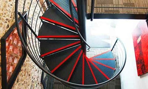 plan view of a back steel spiral staircase with red stripes on steps