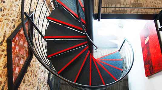 plan view of a back steel spiral staircase with red stripes on steps