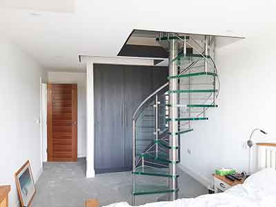 bedroom with bed featuring a glass spiral staircase