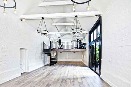 bright white internal shot of a barn conversion with a steel spiral staircase