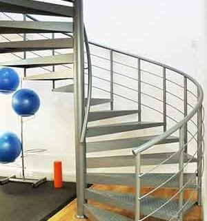 exercise mat and blue exercise balls to left and grey spiral stair to right