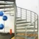 exercise mat and blue exercise balls to left and grey spiral stair to right