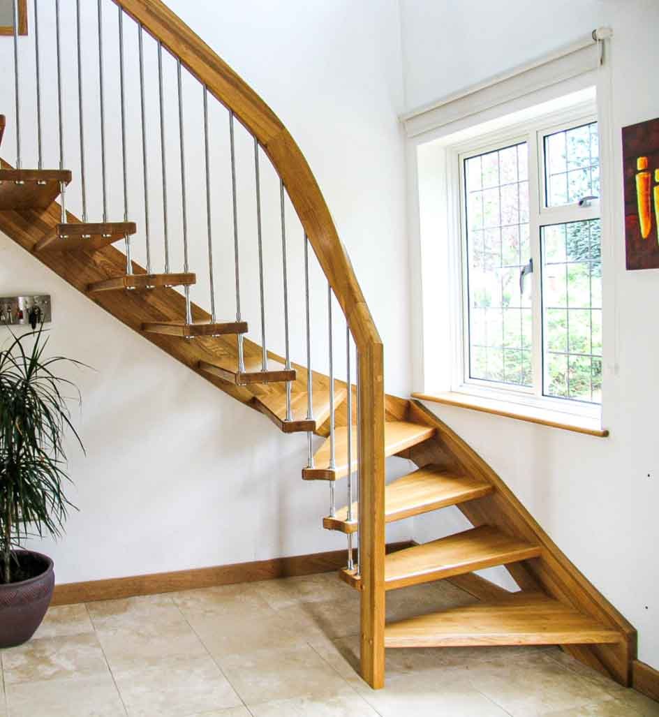 window next to an open riser oak staircase in a hallway