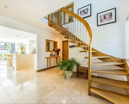 floating style open staircase in a hallway with kitchen beyond
