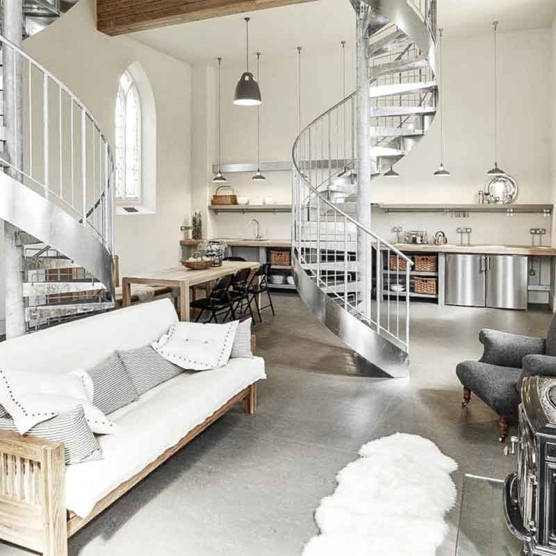 sofa on a concrete floor with spiral stair behind