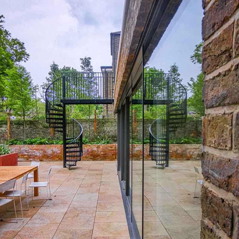 garden patio with table and spiral stair