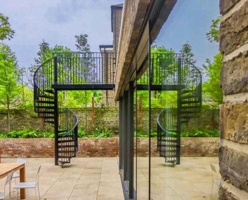 view of spiral stair and patio window with reflection
