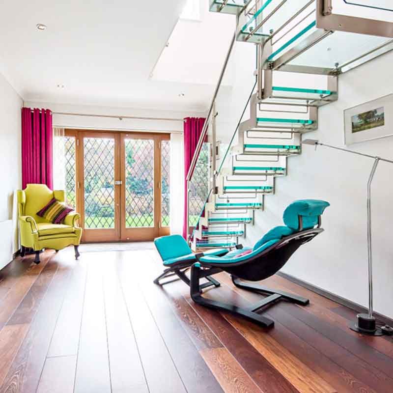 living room with timber flooring and a glass stair