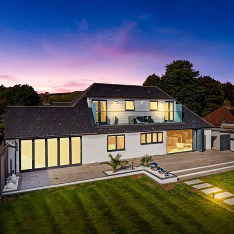 garden and white house with sunset beyond