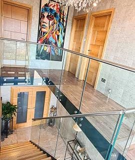 glass balustrade with stainless handrail around the landing area above a model 500 stair