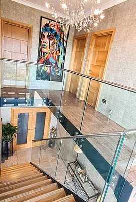 glass balustrade with stainless handrail around the landing area above a model 500 stair