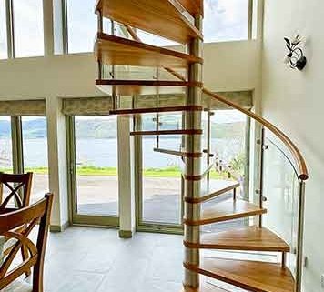 Loch-Ness spiral stair with large window behind with lake view