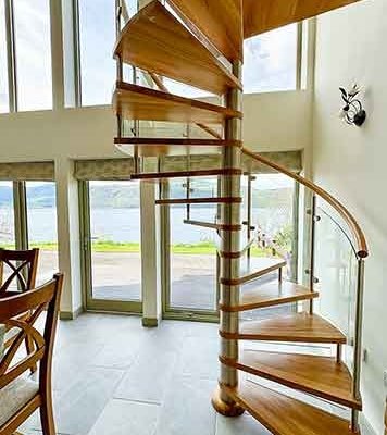 Loch-Ness spiral stair with large window behind with lake view