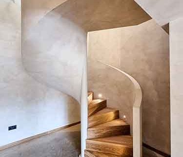 Spiral-stair-with-solid-wall-balustrade-and-oak-treads