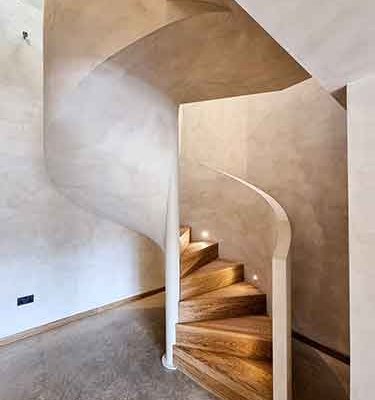 Spiral-stair-with-solid-wall-balustrade-and-oak-treads