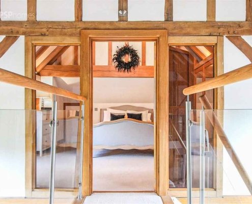 Glass-Staircase-Haywards-Heath-landing-balustrade-and-bedroom-beyond