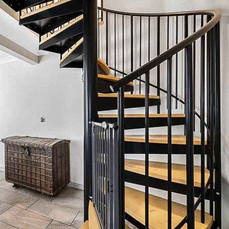 Black-steel-and-wood-spiral-stair-in-a-living-area-in-a-house
